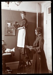 Madge Carr Cook hangt schilderijen op met haar dienstmeid, c.1904